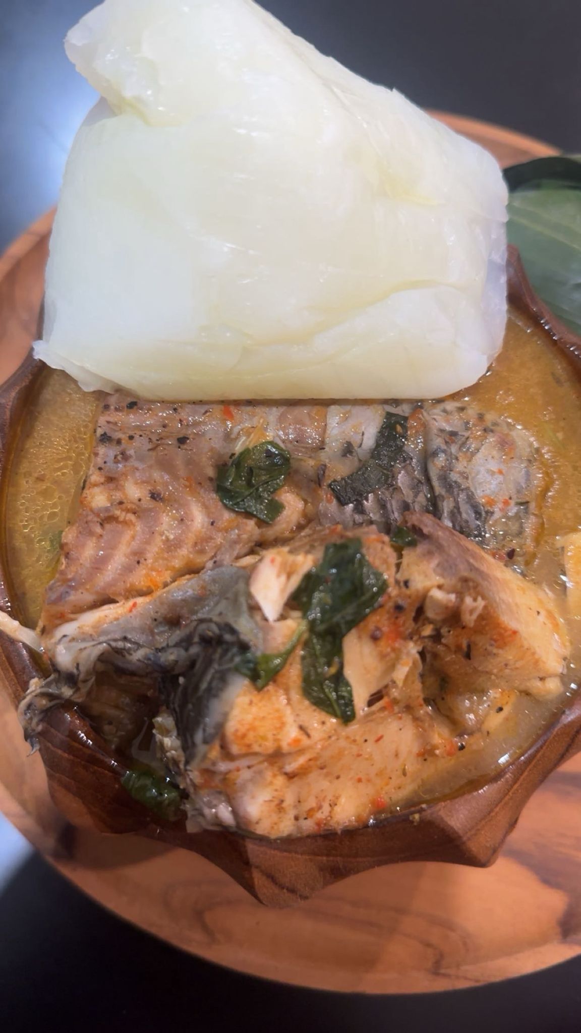 Fish pepper soup in a wooden bowl