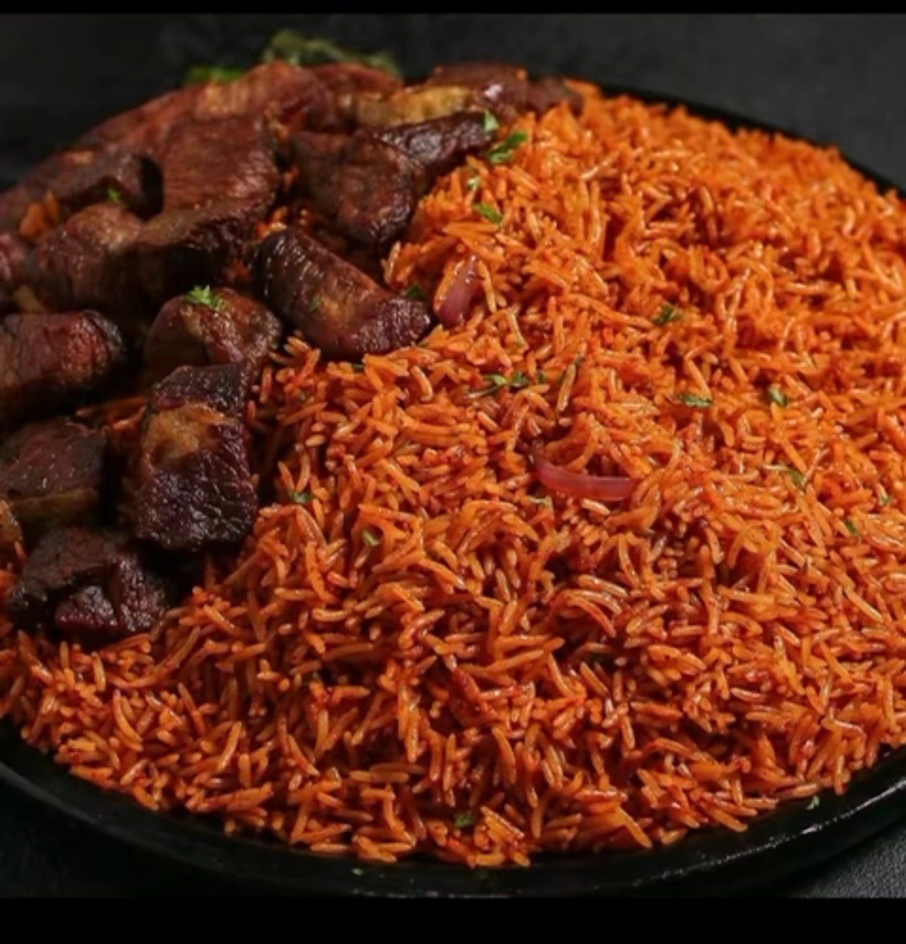 A generous plate of Nigerian jollof rice with meat